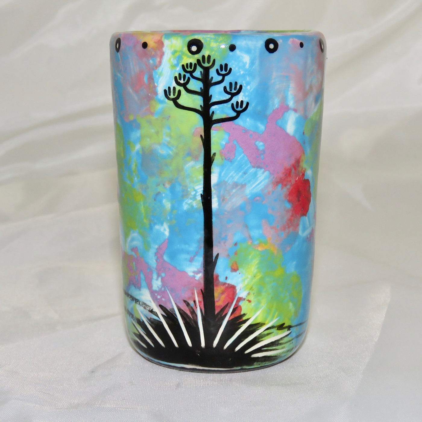 Mana Pottery clay shot glass featuring turtle on one side and native Aravaipa vegetation on reverse, on a turquoise blue backround. This image shows the reverse side.