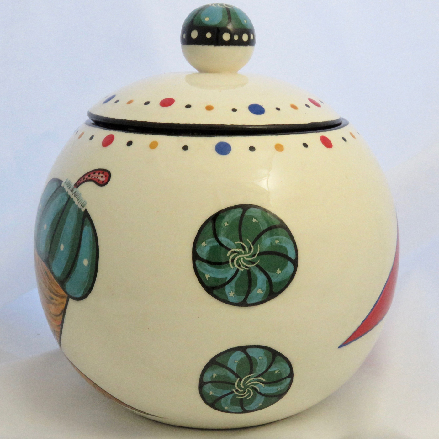 Sideview of Mana Pottery canister with Peyote roots on one side and Firebird on reverse and confetti interior.