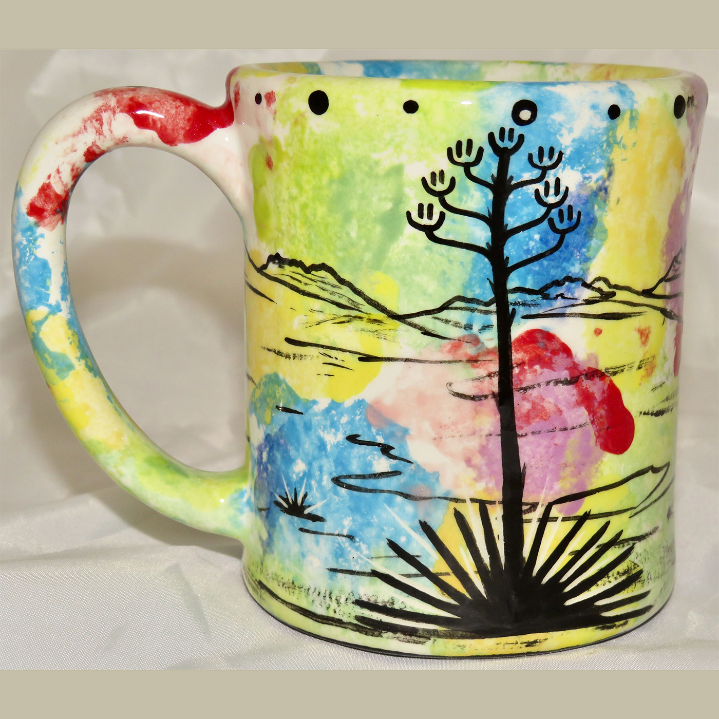 Mana Pottery e-mug featuring leaping jackrabbit and desert landscape on reverse sides, on confetti background.