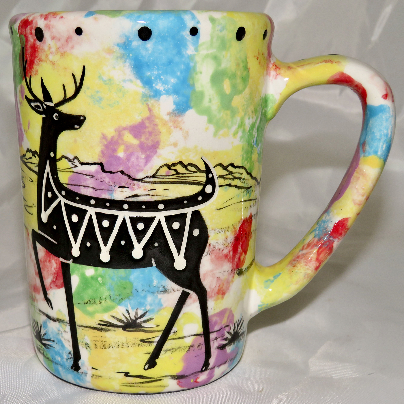 Mana Pottery Large Mug featuring deer and desert landscape on reverse sides, on mixed color background.