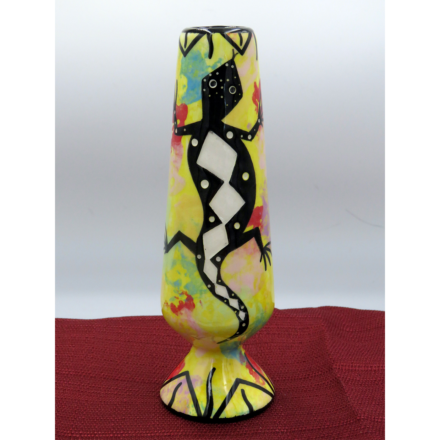 Mana Pottery bud vase featuring gecko with schematic design on reverse, on bright yellow background.