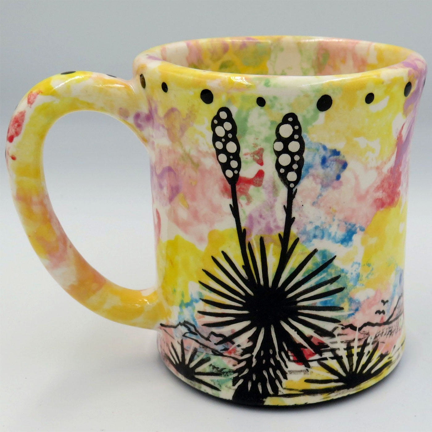 Mana Pottery e-mug featuring hovering hummingbird in desert landscape on confetti background.