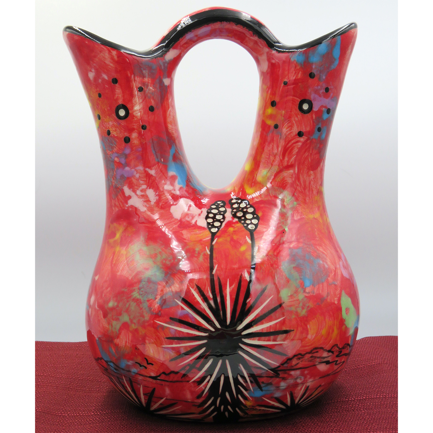 Mana Pottery medium wedding vase featuring kissing hummingbirds and desert landscape on crimson backgroundMana Pottery medium wedding vase featuring kissing hummingbirds and desert landscape on reverse sides on blue background
