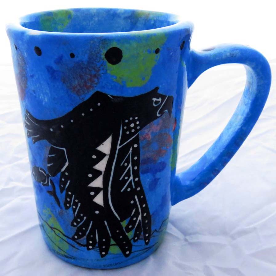 Image of Mana Pottery Large Mug featuring eagle with fish in talons and desert plants on reverse, on blue background.