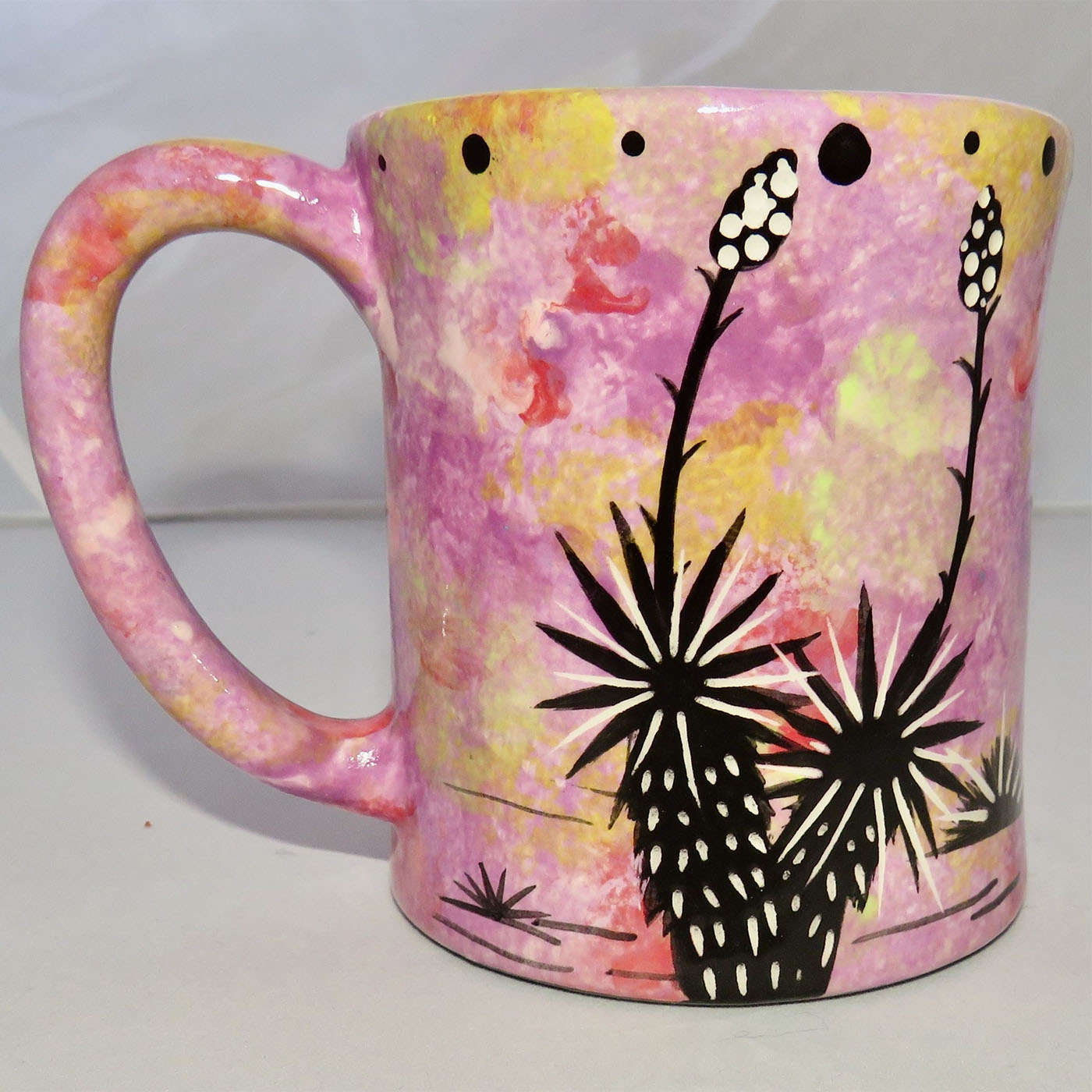 Image of Mana Pottery E-mug featuring butterfly on Peyote on one side and desert vegetation on the other on a purple-yellow background.