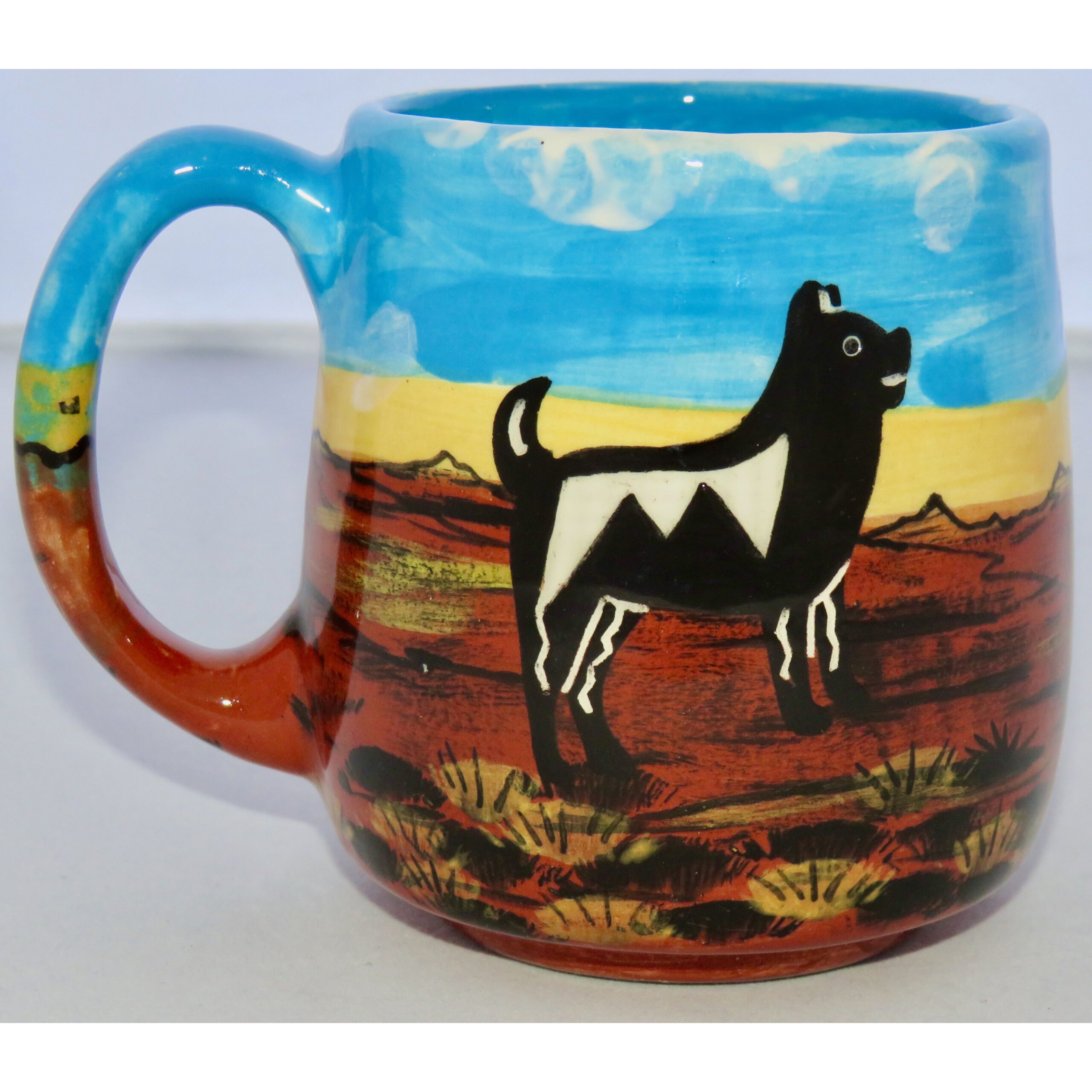 Mana Pottery Country Cup featuring quail family one side and doggy on the other, on background of desert earth and sky