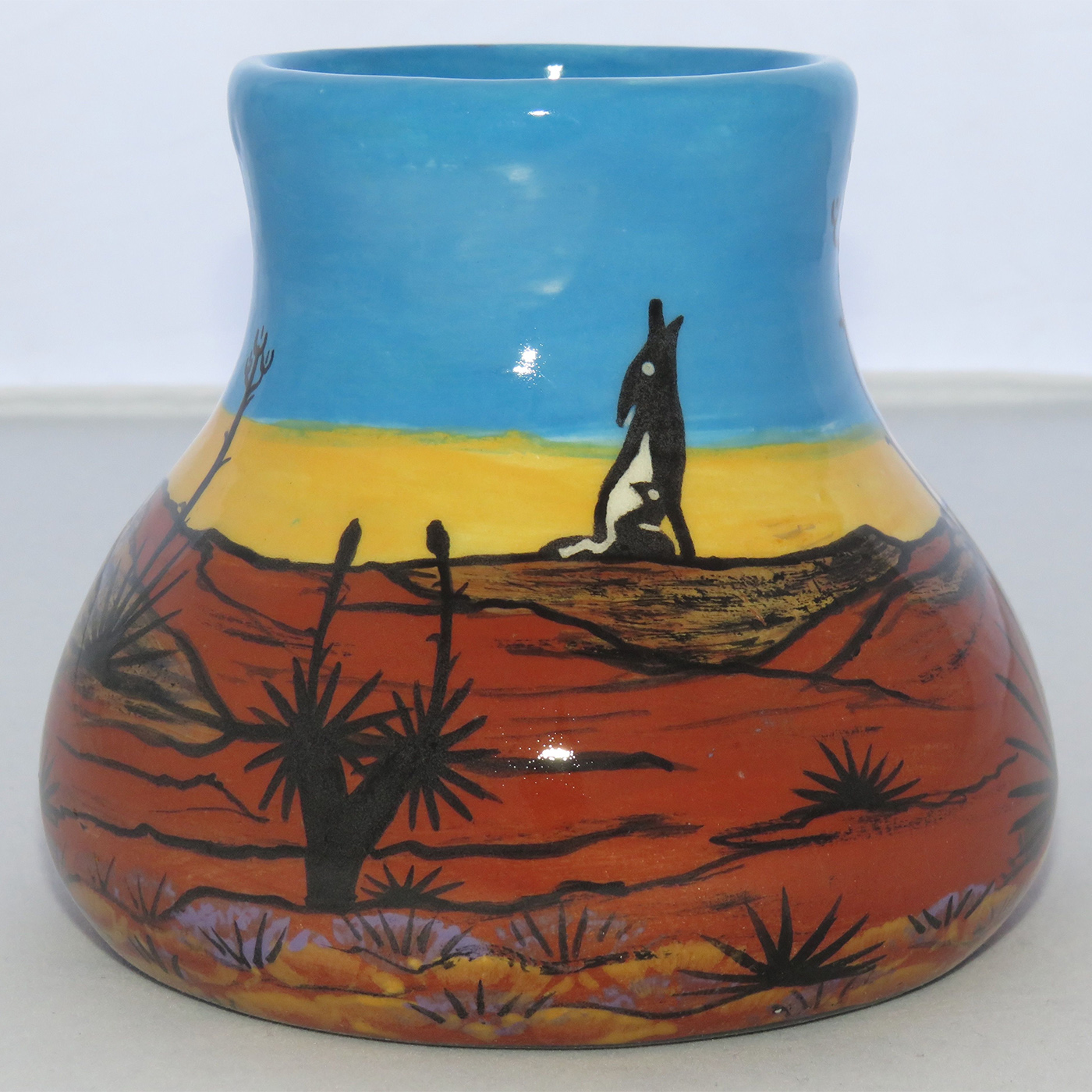 Mana Pottery No Spill Mug featuring quail family and coyote against backdrop of desert and sky at glorious cusp of day.