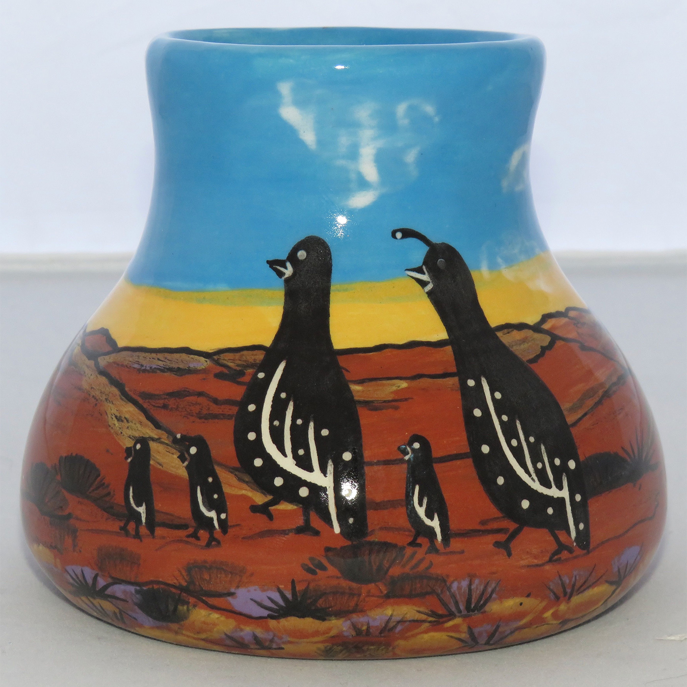 Mana Pottery No Spill Mug featuring quail family and coyote against backdrop of desert and sky at glorious cusp of day.