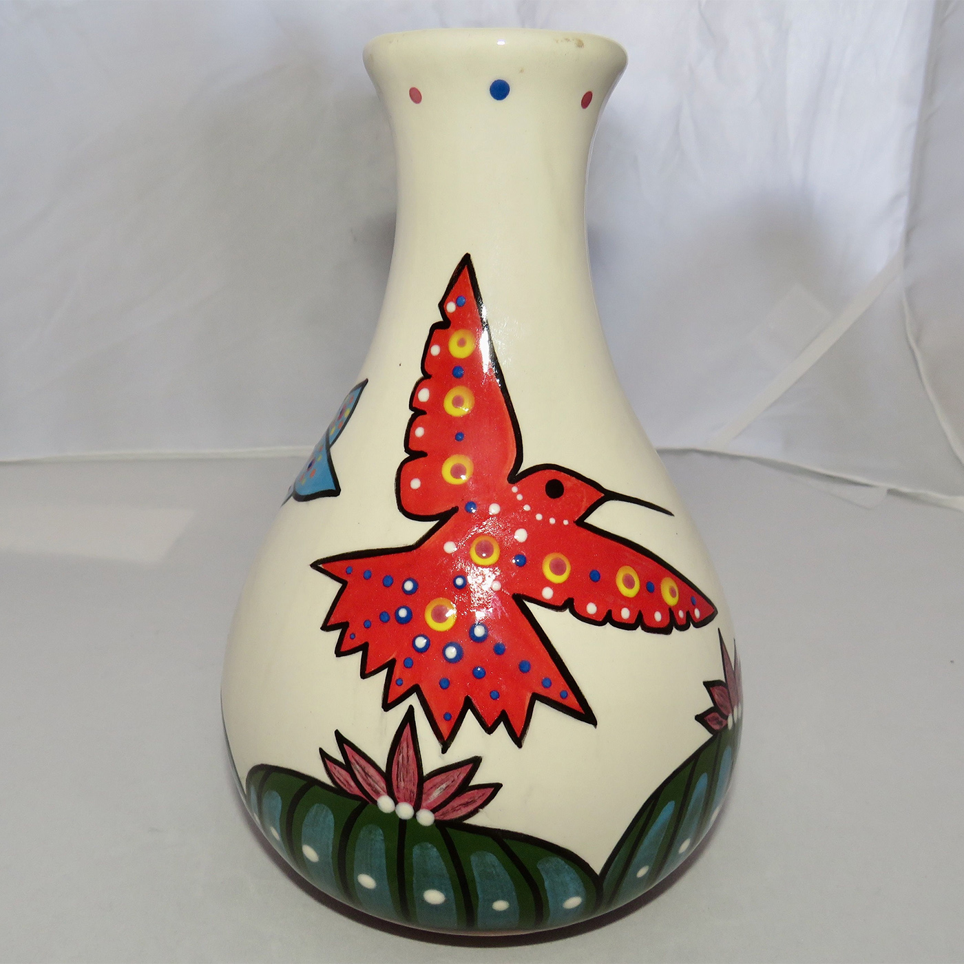 Mana Pottery Teardrop Vase featuring a blue, red and orange hummingbird hovering above Peyote.
