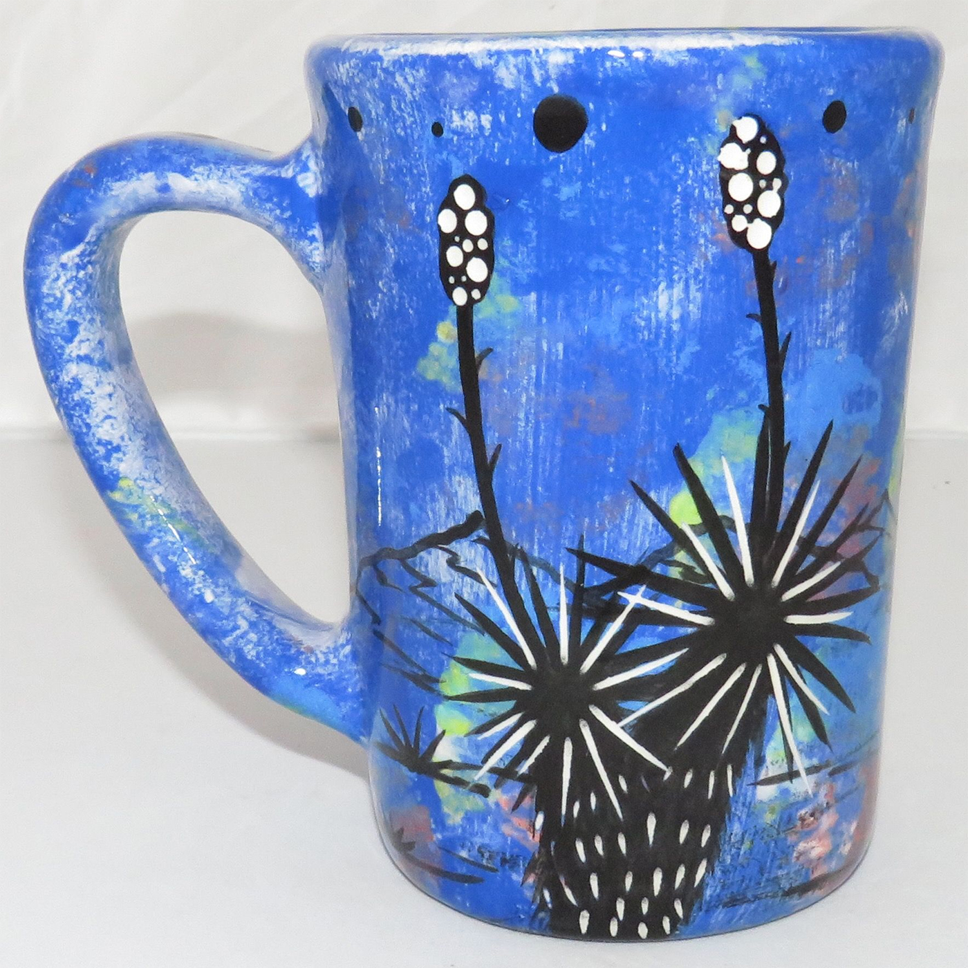 Mana Pottery large mug featuring kitty and desert veg on opposite sides on a blue background