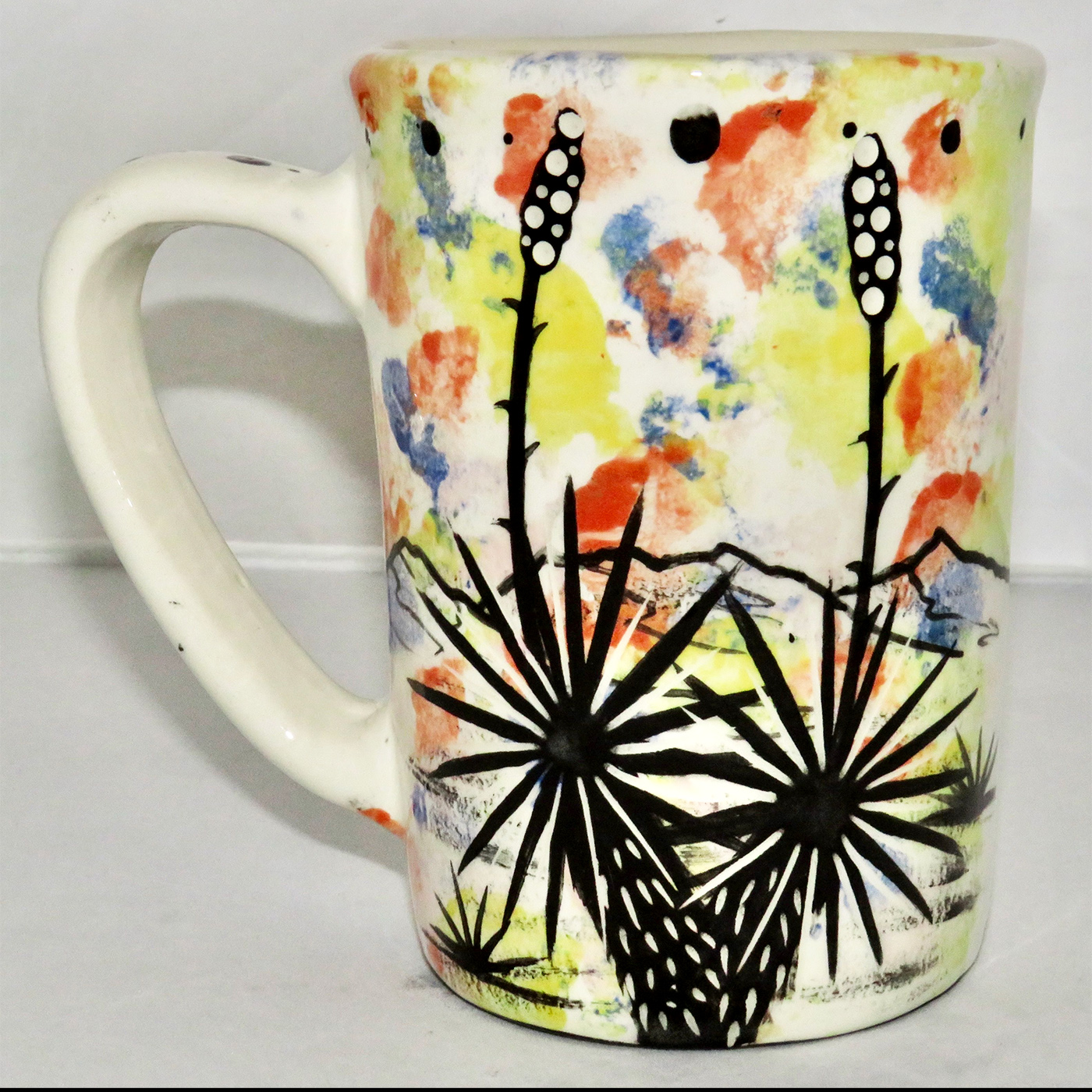 Mana Pottery large mug featuring Dancing Peyote with green top on one side and Aravaipa desert scene on reverse