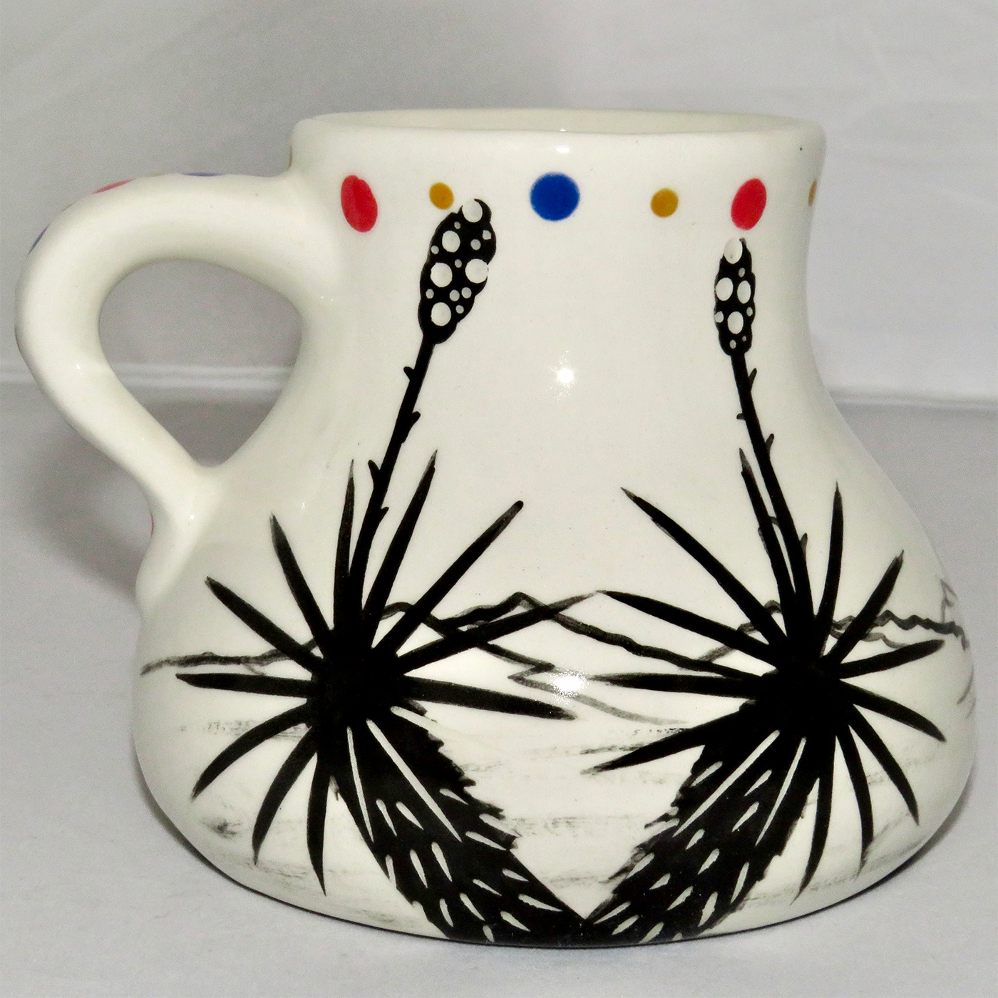 Mana Pottery No Spill Mug featuring Peyote Duo on one side and desert vegetation on the other.