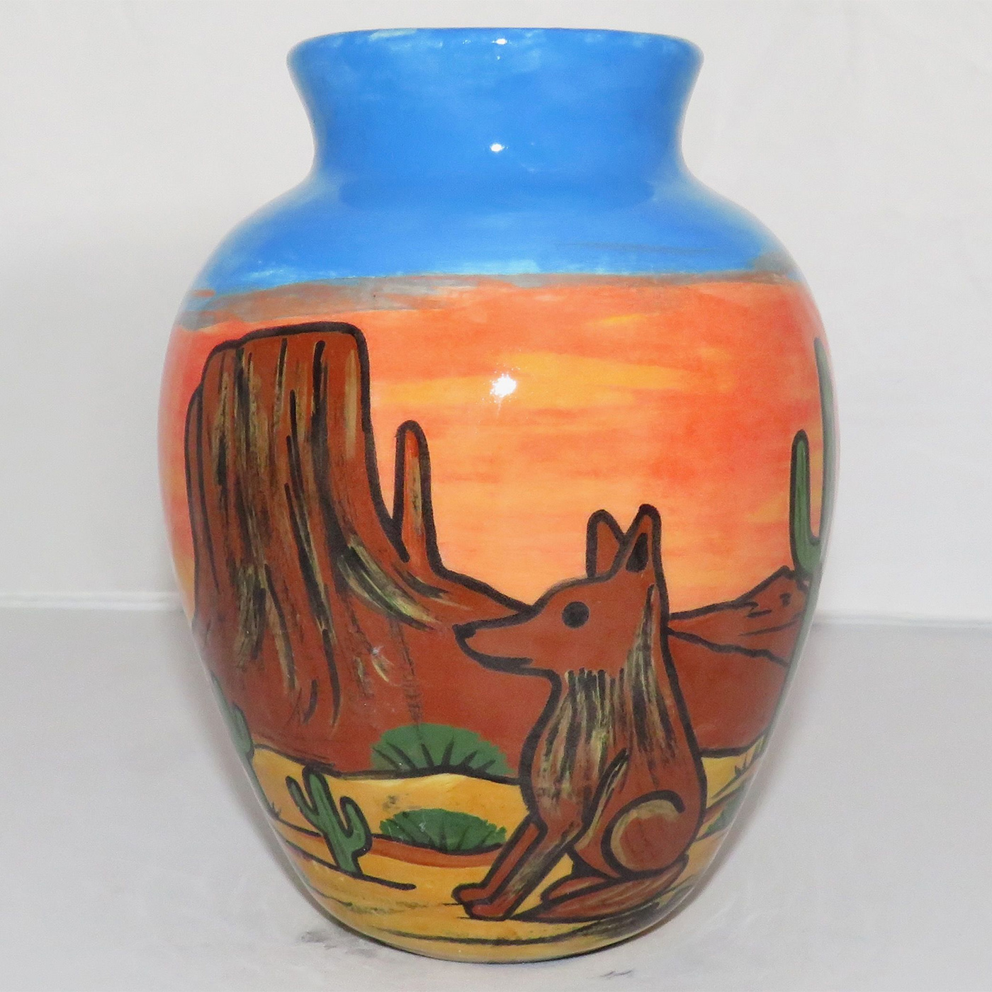 Mana Pottery Six Inch Vase featuring quail family on one side and coyote on reverse with desert and flaming sky in background.