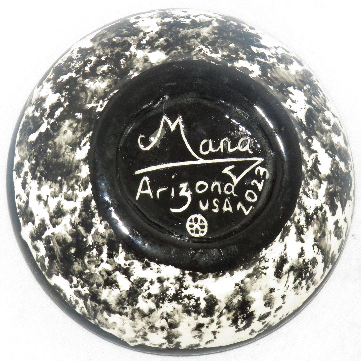 Mana Pottery Holy Bowl featuring Kokopelli and animal followers, on bright yellow confetti. This is the black and white marbled underside.