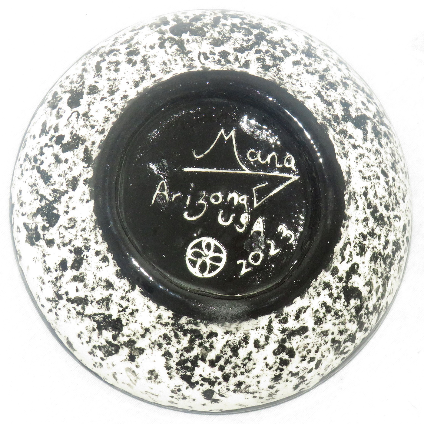 Mana Pottery Holy Bowl featuring Kokopelli, and black and white marbled underside. This view shows the underside.