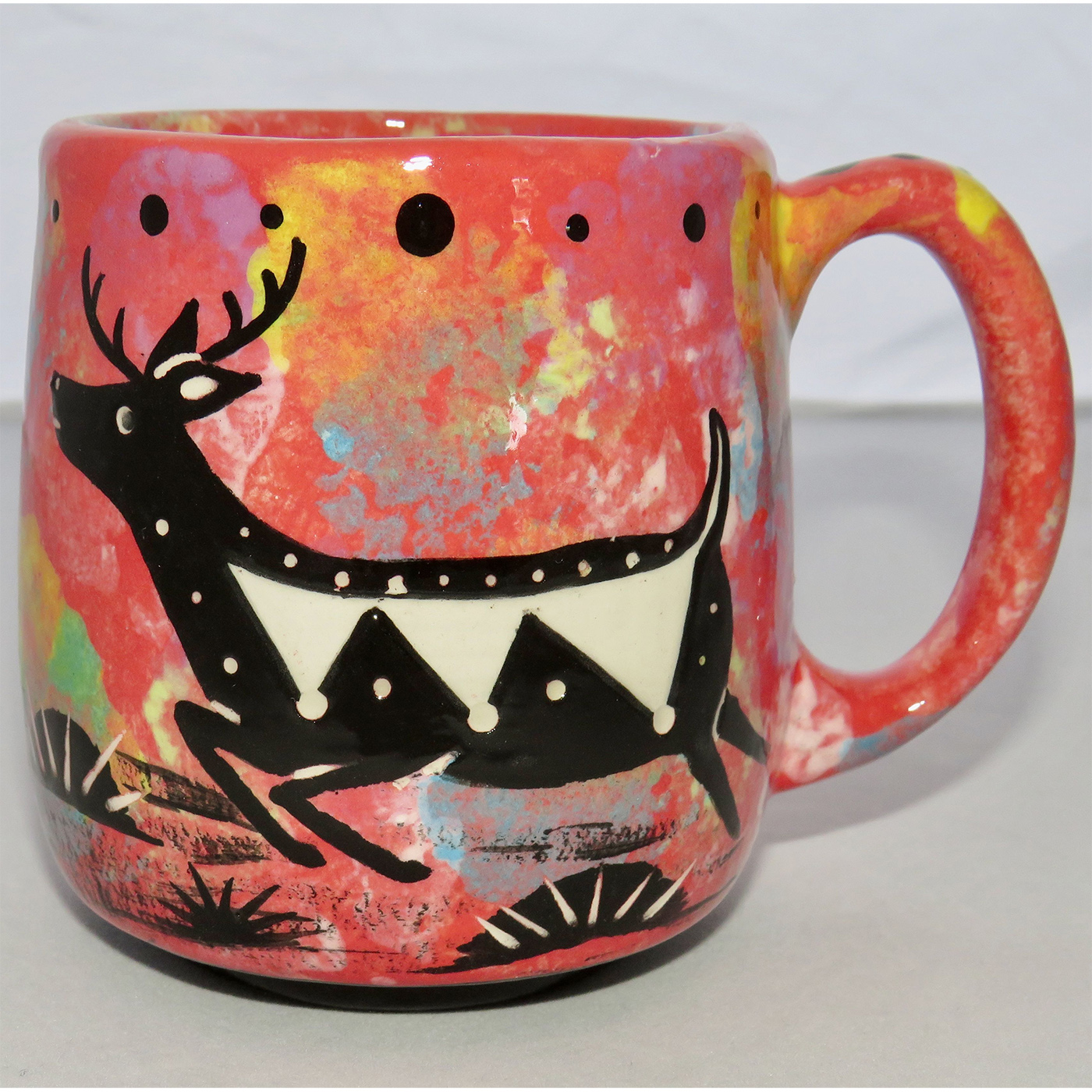 Photo of Mana Pottery Country Cup featuring a running deer in the desert, on a rose background.