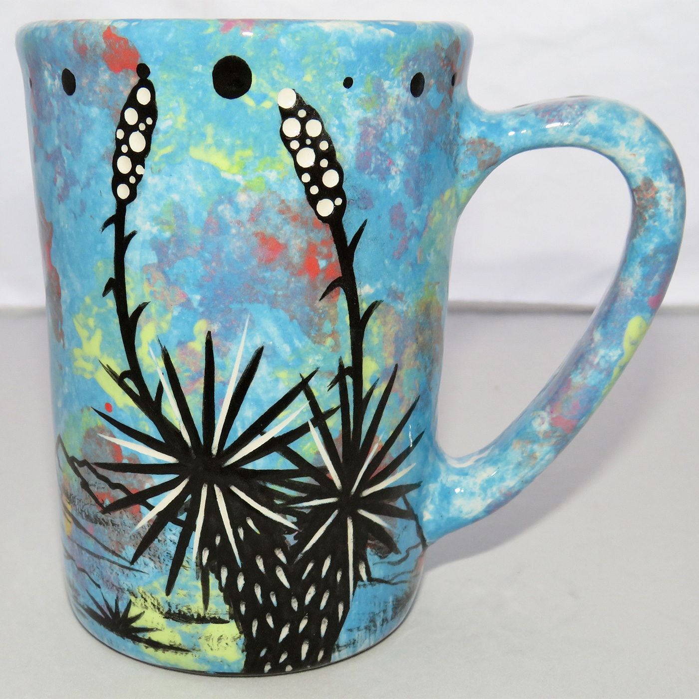 Photo of Mana Pottery Large Mug featuring blue coyote howling in turquoise desert.