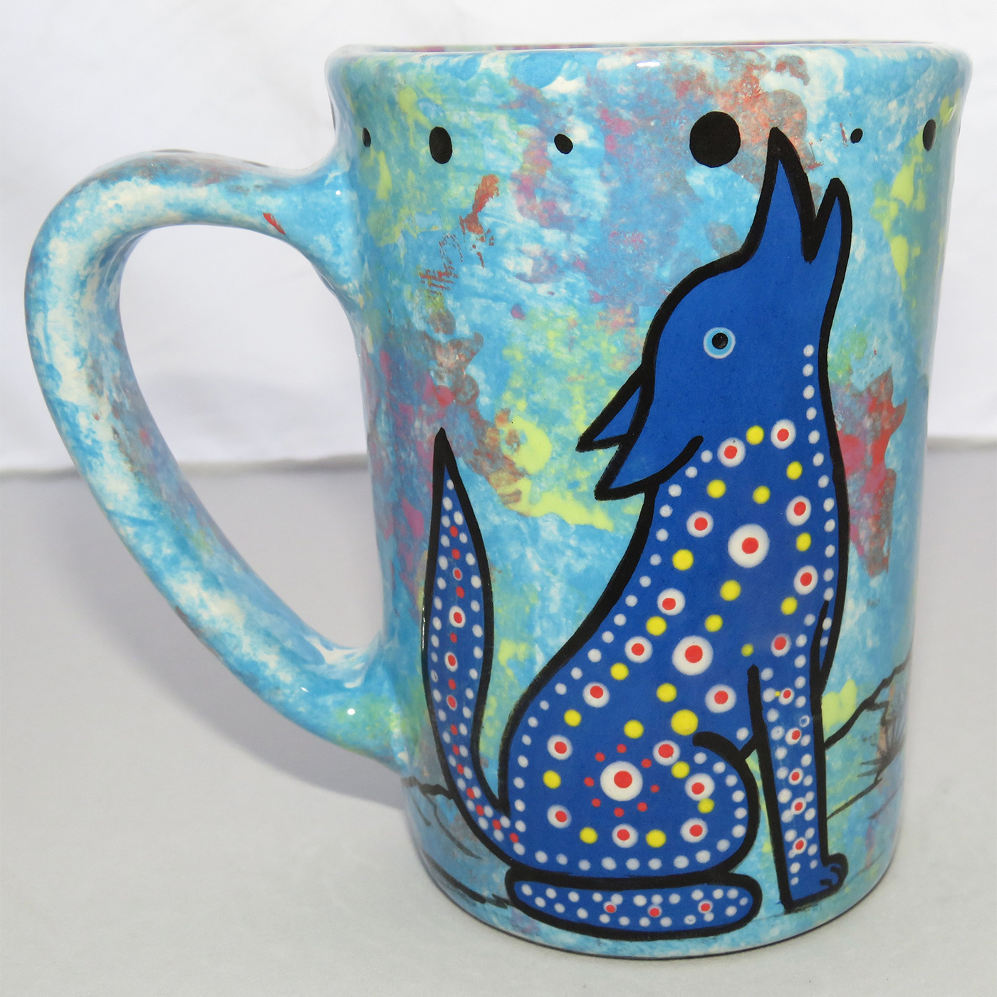 Photo of Mana Pottery Large Mug featuring blue coyote howling in the desert, on a background of turquoise.