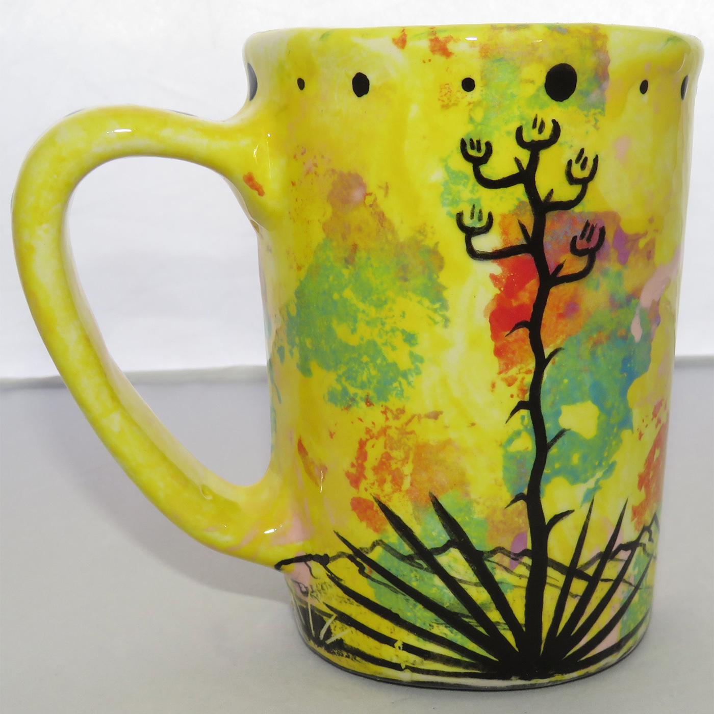 Photo of Mana Pottery Large Mug featuring butterfly resting on Peyote button against a bright yellow desert background.