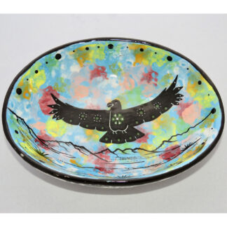 Photo of Mana Pottery Oval Bowl featuring hawk in flight high over desert, with black and white marbled underside.
