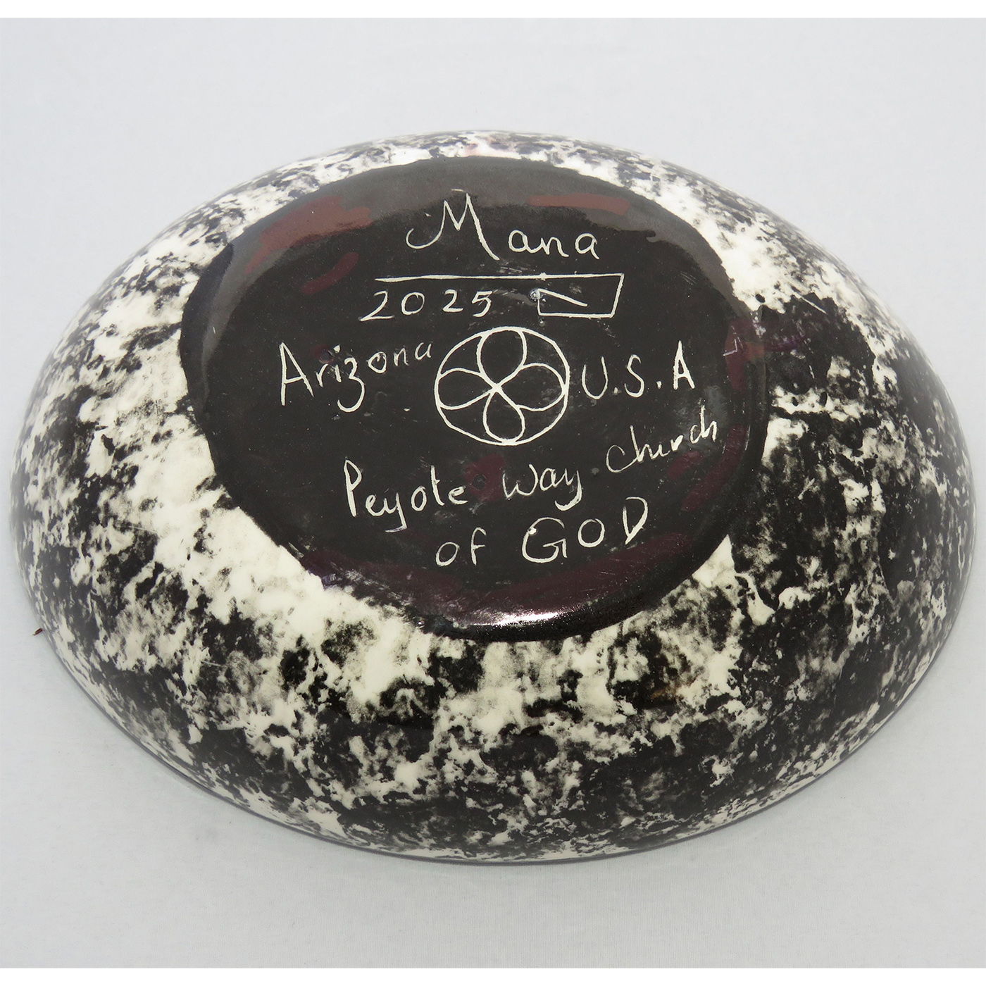 Photo of Mana Pottery Oval Bowl featuring howling coyote in desert on rose background, with black and white marbled underside.
