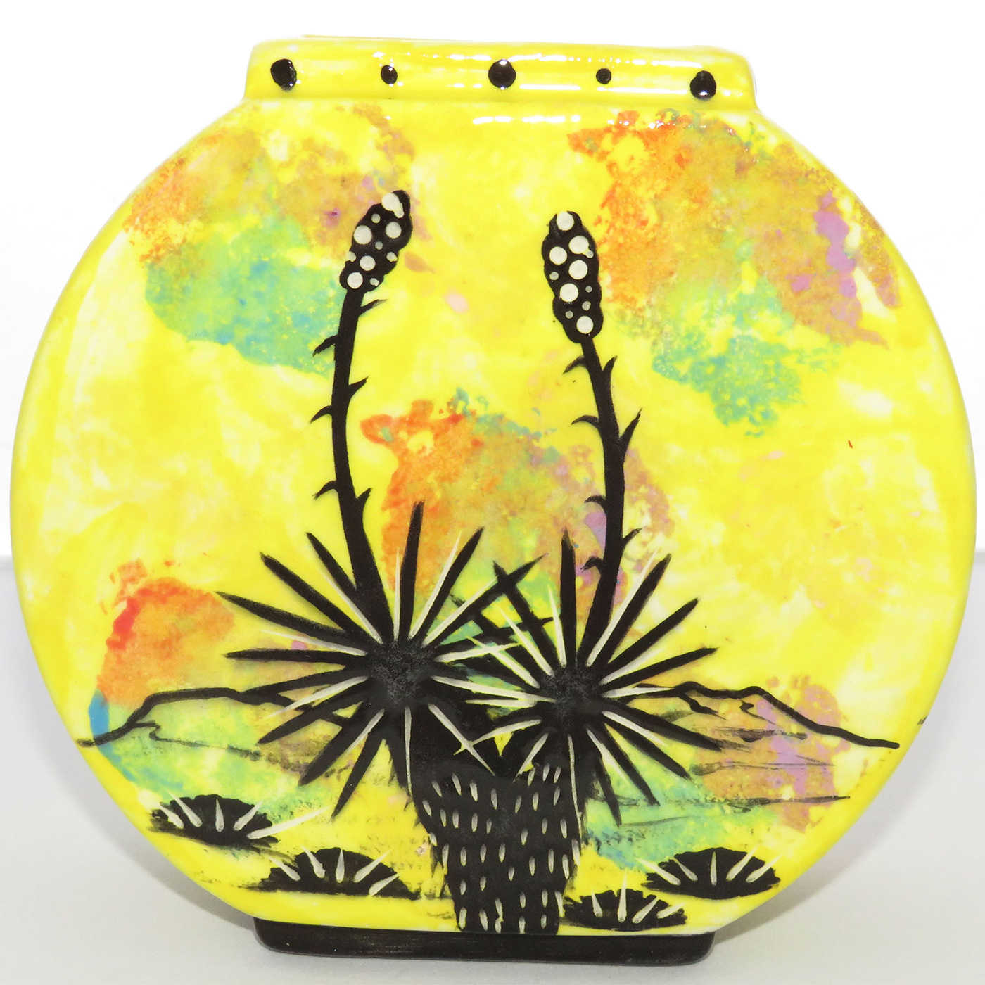 Photo of Mana Pottery Pillow Vase featuring kitty on one side and desert plants on reverse, on a bright yellow background.