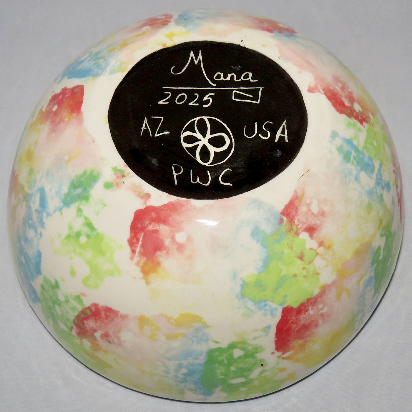 Photo of Mana Pottery Seven Inch Bowl featuring hawk in flight high over desert. Underside is a multicolored pattern.