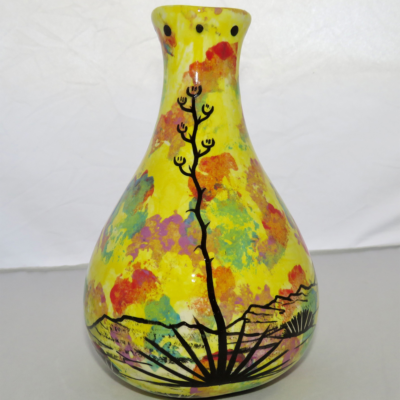 Photo of Mana Pottery Teardrop Vase featuring quail family in desert, on bright yellow background.