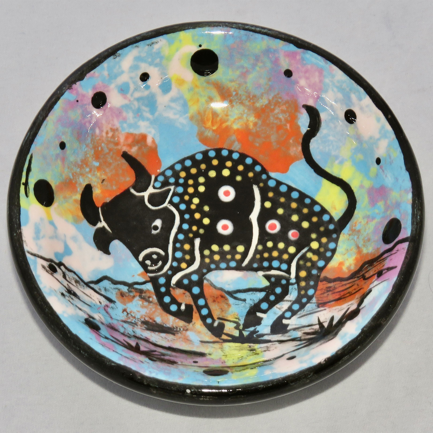 Photo of Mana Pottery Holy Bowl featuring bull on turquoise background, and black and white marbled underside.