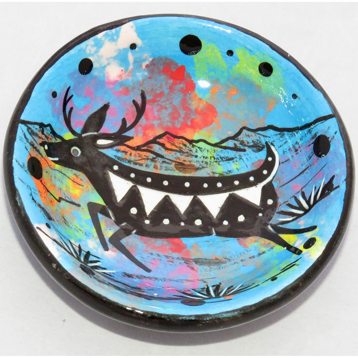 Photo of Mana Pottery Holy Bowl featuring deer on turquoise background, and black and white marbled underside.