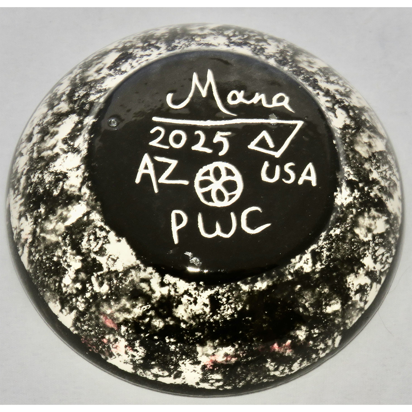 Photo of Mana Pottery Holy Bowl featuring gecko on coral background, and black and white marbled underside.