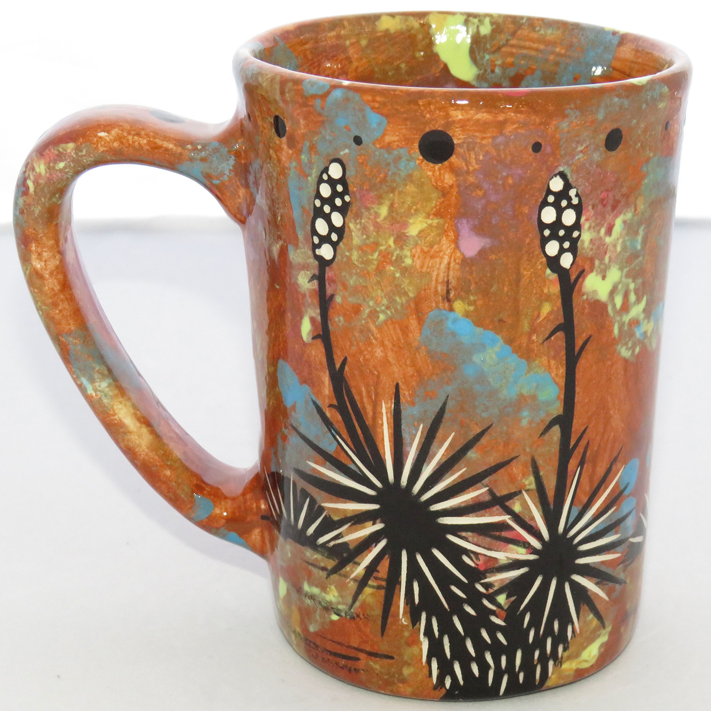 Photo of Mana Pottery Large Mug featuring javelina and baby and desert scene on opposite sides, on a chocolate mix background