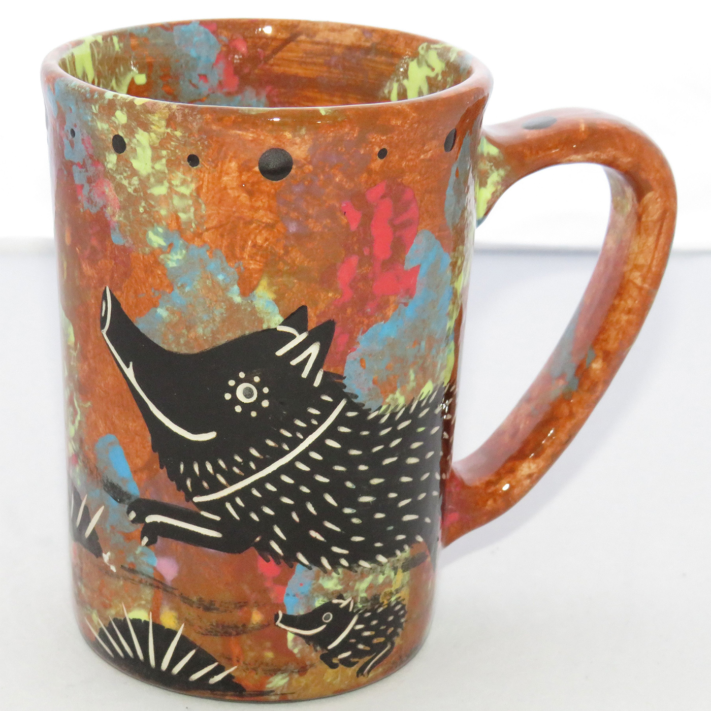 Photo of Mana Pottery Large Mug featuring javelina and baby and desert scene on opposite sides, on a chocolate mix background