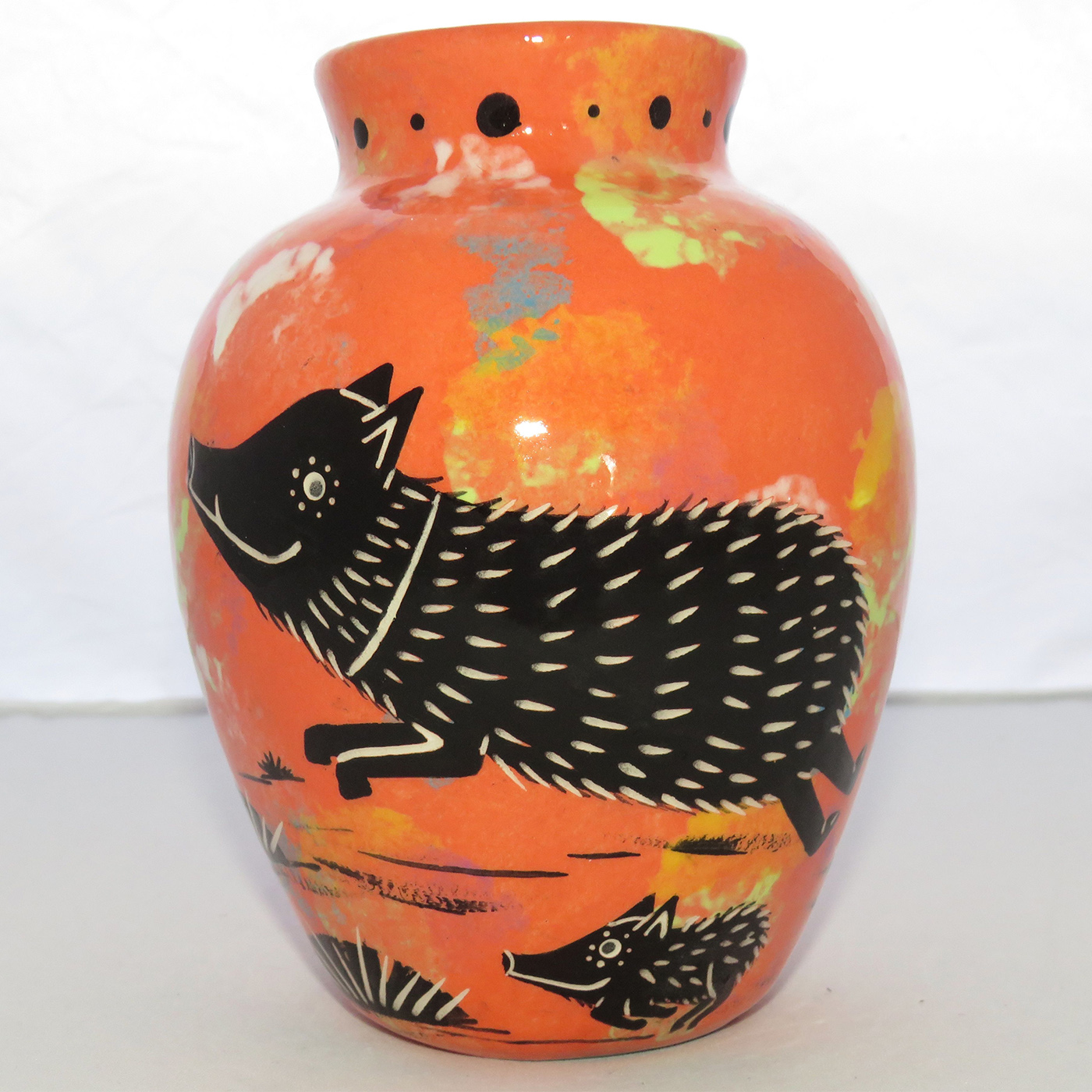 Photo of Mana Pottery Six Inch Vase featuring javelina and baby on one side and desert plants on reverse, all on a coral background.