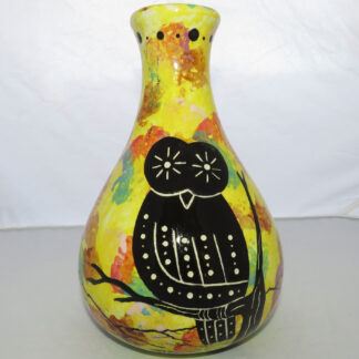 Photo of Mana Pottery Teardrop Vase featuring owl in desert landscape, on bright yellow background.