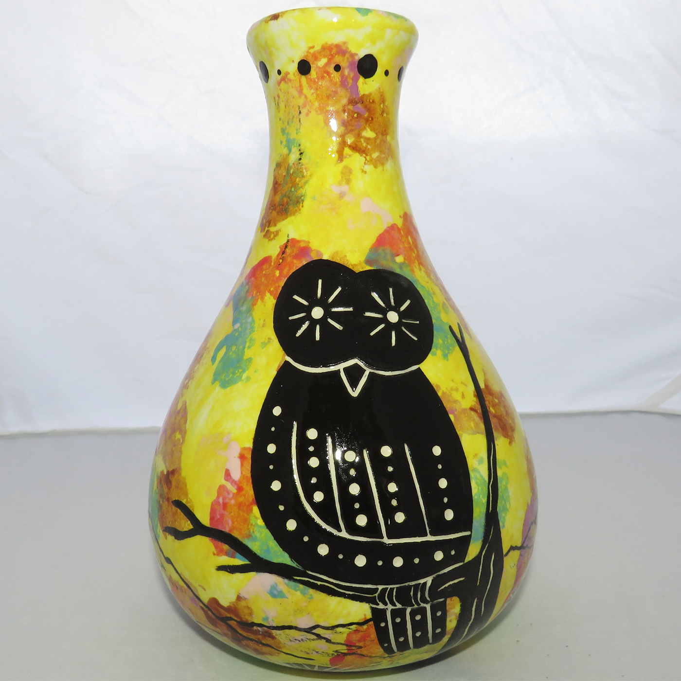 Photo of Mana Pottery Teardrop Vase featuring owl in desert landscape, on bright yellow background.