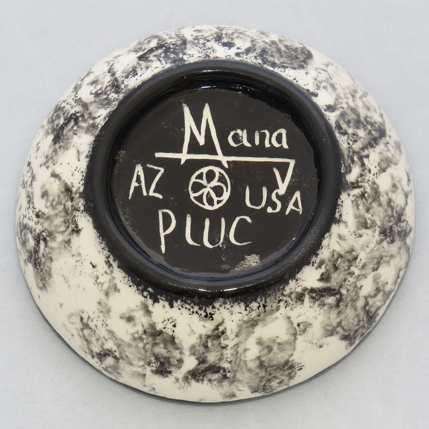 Image of Mana Pottery Holy Bowl featuring hawk in flight, high in a brightly colored desert sky. This view shows the black and white marbled underside.