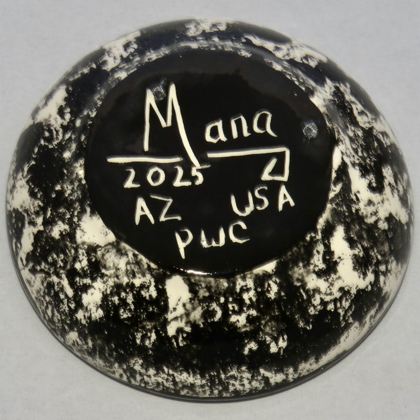 Image of Mana Pottery Holy Bowl featuring hawk in flight, high in a deep blue sky. This view shows the marbled black and white underside.