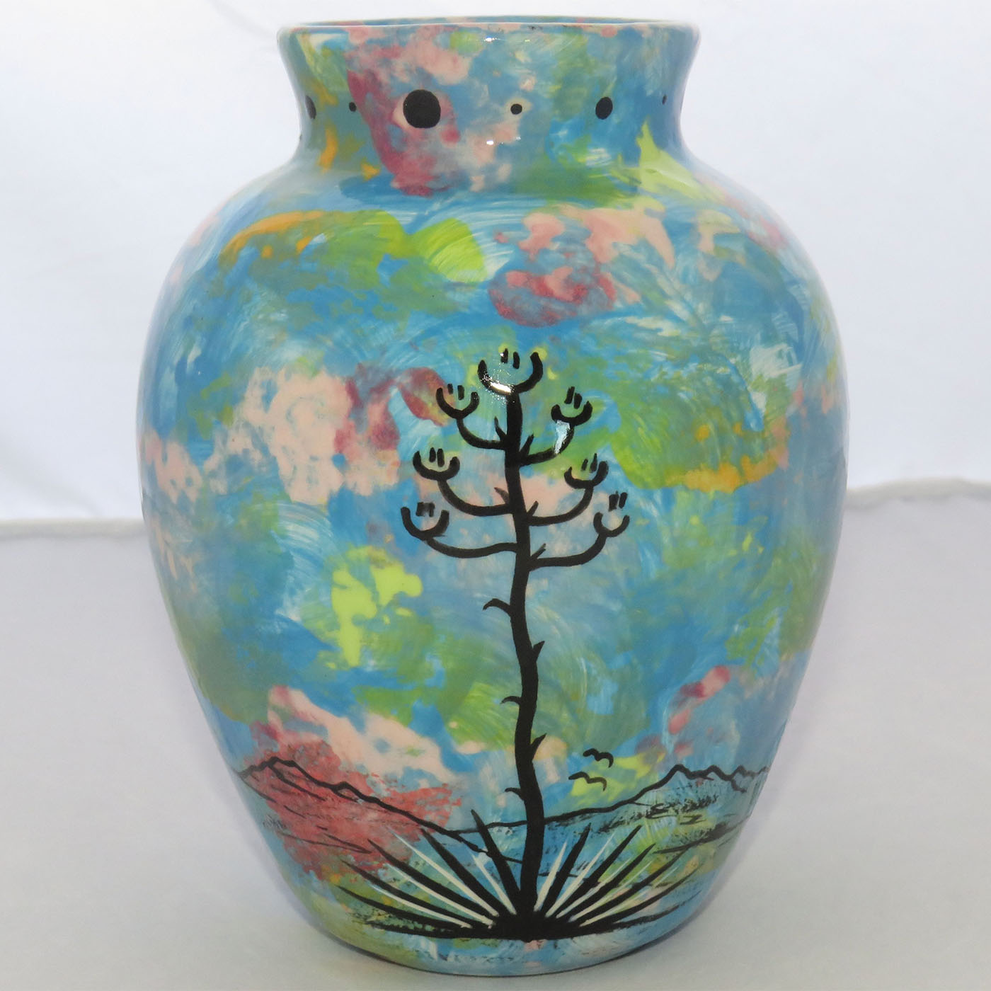 One view of Mana Pottery Six Inch Vase featuring deer running through desert on turquoise blue background.
