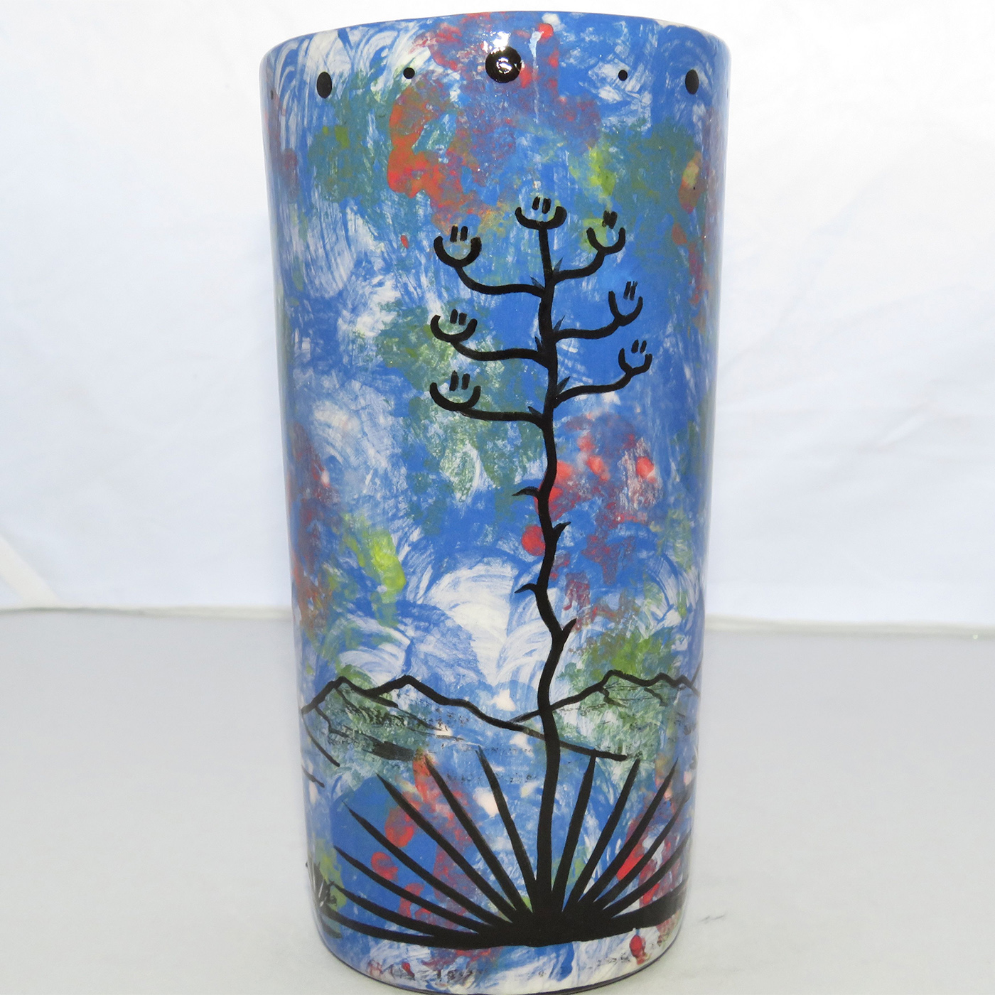 Image of Mana Pottery Tumbler-Vase featuring Chakra Being and desert landscape on reverse sides on a background of blue.