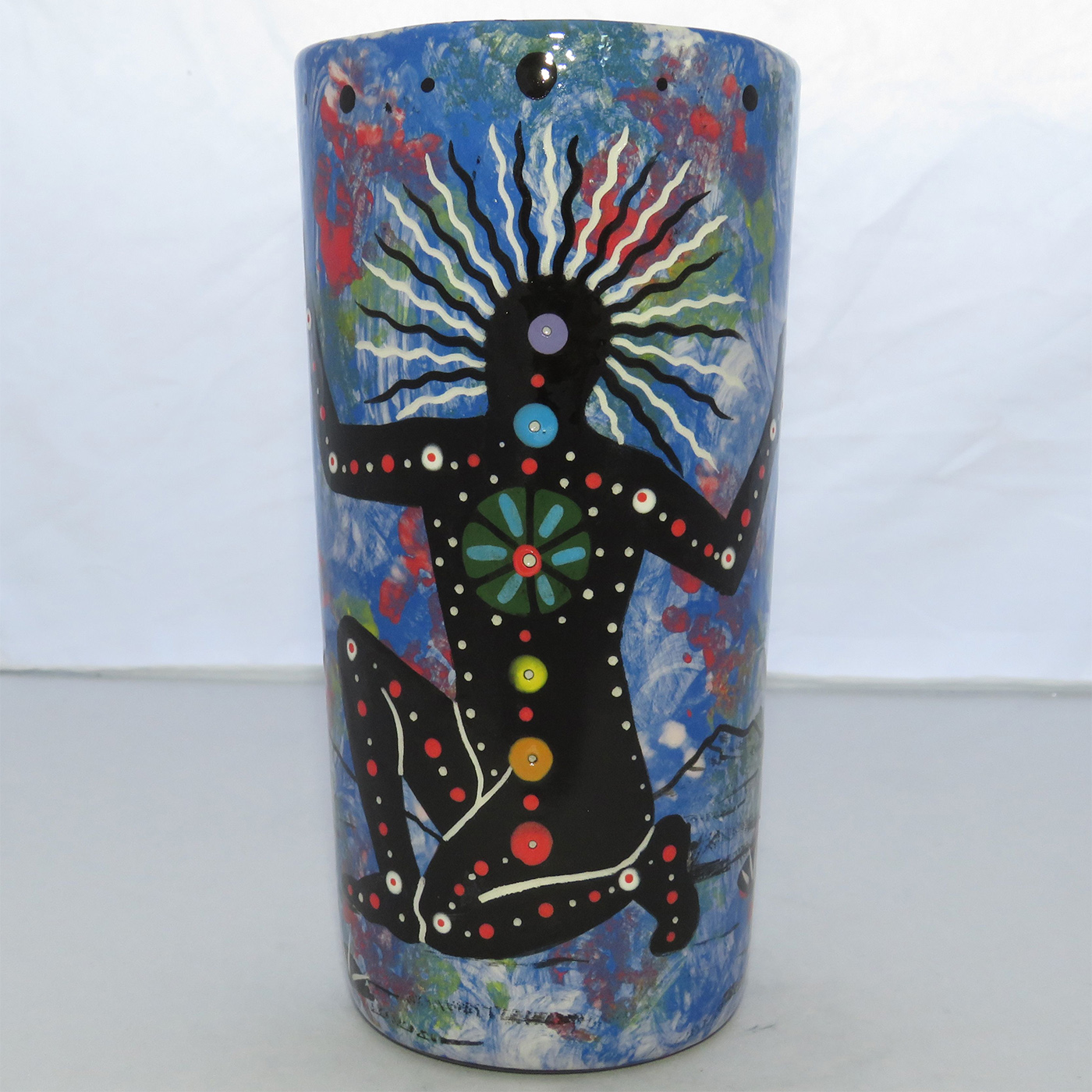 Image of Mana Pottery Tumbler-Vase featuring Chakra Being and desert landscape on reverse sides on a background of blue.