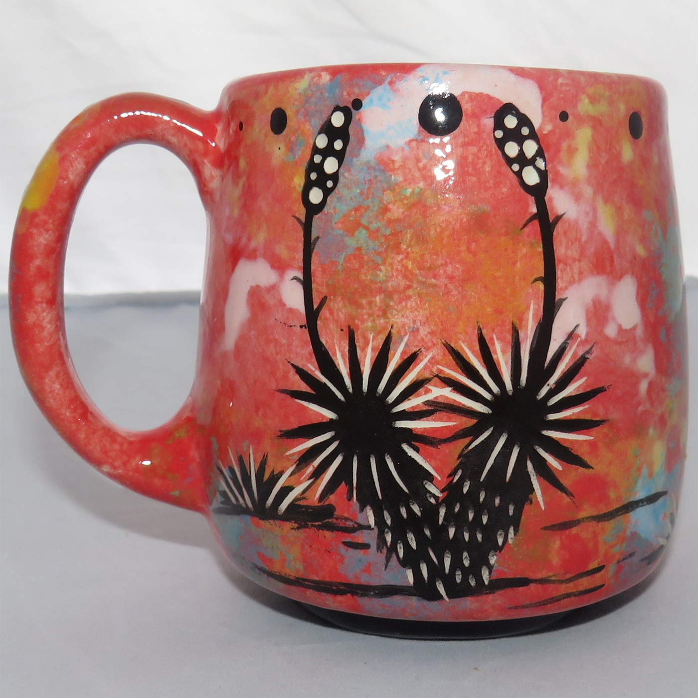 Image of Mana Pottery Country Cup featuring a Puma lion on one side and yucca plants on the other, all on a rose mix background.