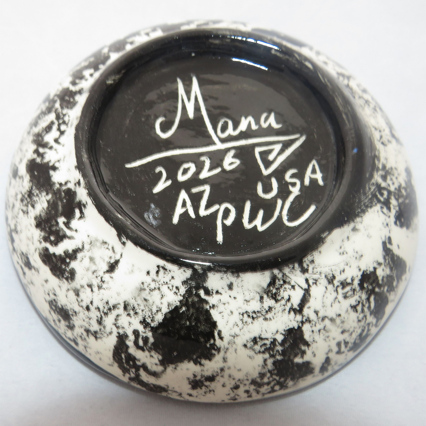 Image of Mana Pottery Holy Bowl featuring butterfly against a rose and gold background. Underside view shows black and white marbled pattern.