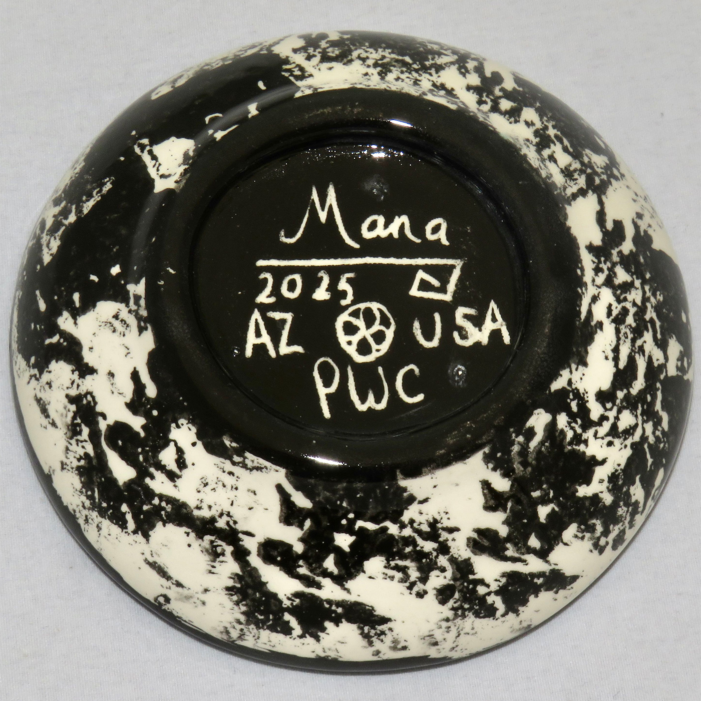 Image of Mana Pottery Holy Bowl featuring butterfly against turquoise blue and other colors. Underside view shows black and white marbled pattern.