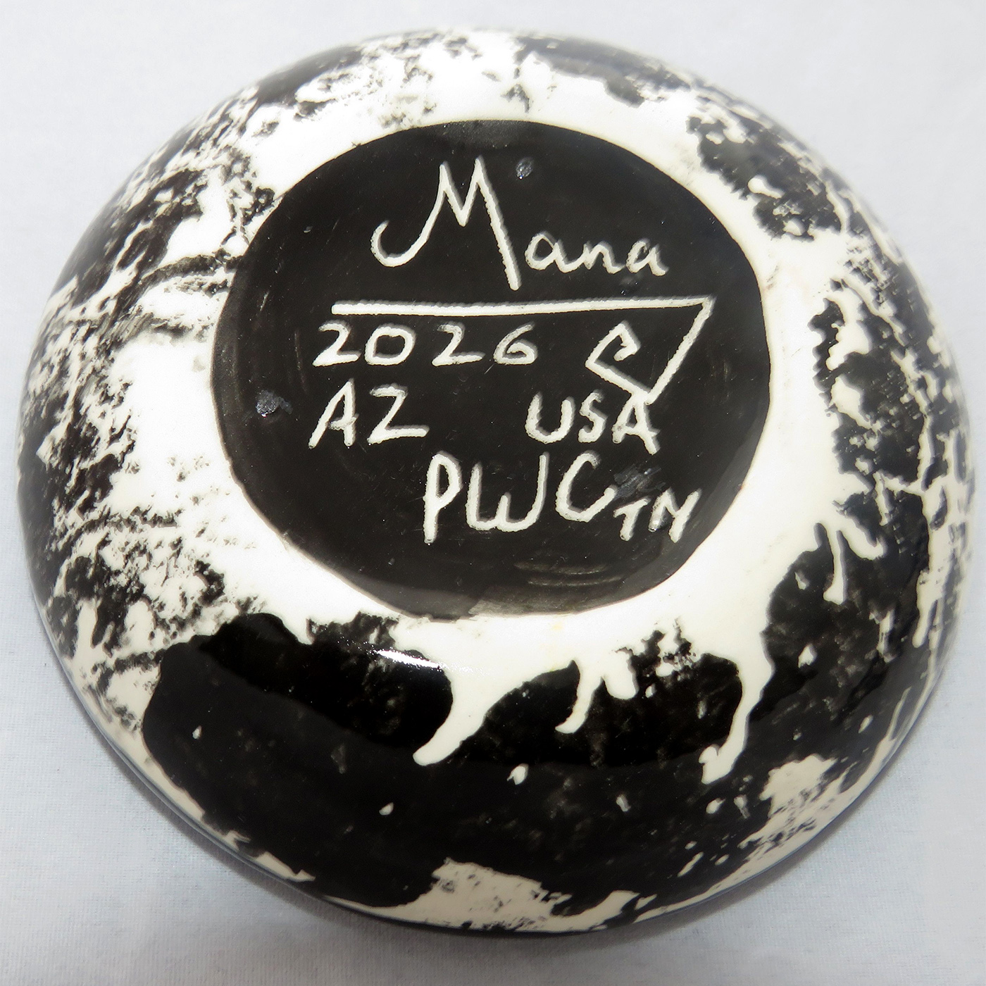 Image of Mana Pottery Holy Bowl featuring Kokopelli on turquoise blue and other colors. Underside view shows black and white marbled pattern.