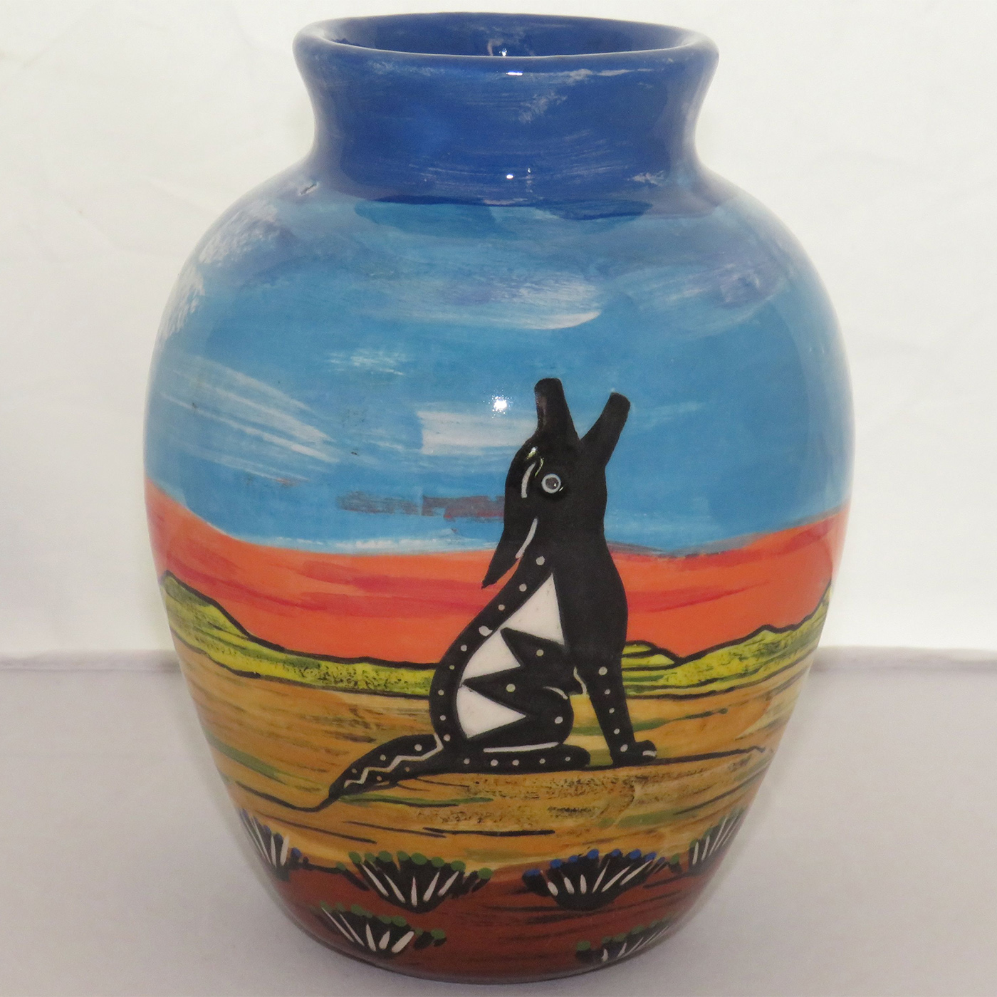 Mana Pottery Six Inch Vase featuring hawk in flight on one side and howling coyote on the other, against desert and flame red sky.